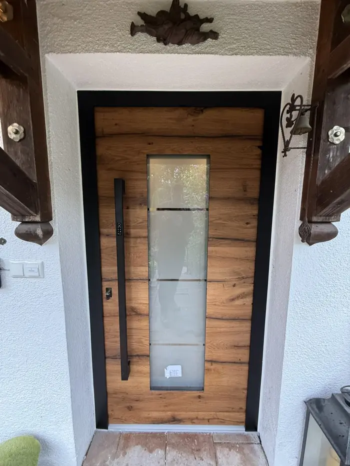 Moderne Haustür in Eiche-Optik mit Glaseinsatz und Edelstahlgriff, montiert von Bauelemente Ruffing